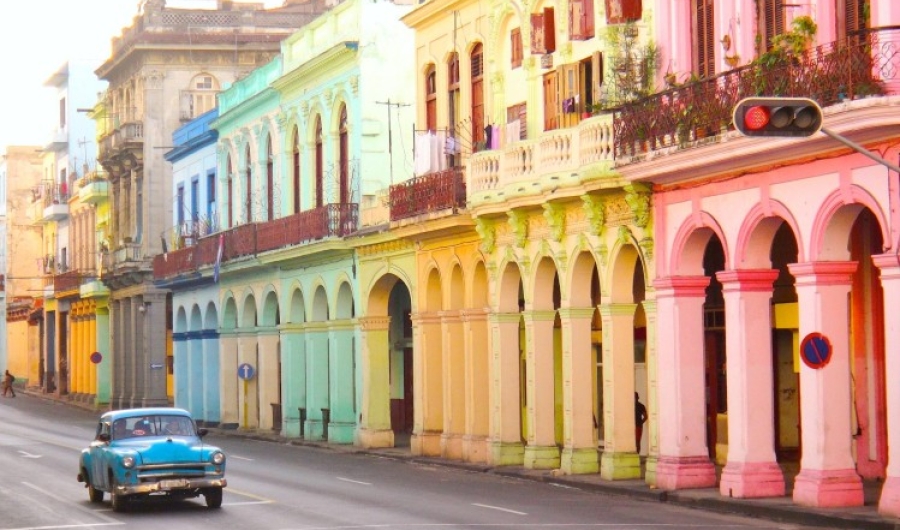 Fotografía de casas caribeás de colores y carro antiguo