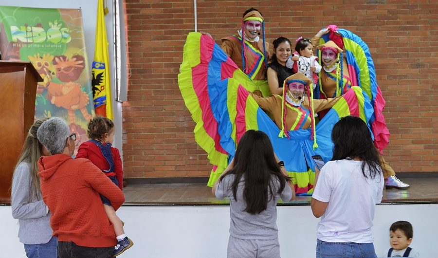 Artistas escénicos del Programa Nidos tomándose fotos con familias