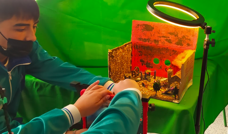 Niños organizando una maqueta con un foco de luz 