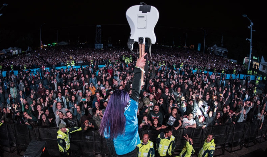 Guitarrista con instrumento en el aire frente a multitud de Rock al Parque