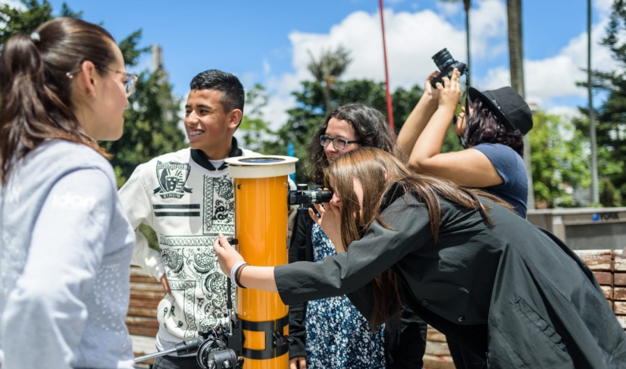 Personas al aire libre en actividad con telescopio