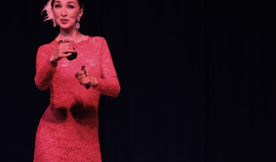 Mujer danzando en escenario con castañuelas