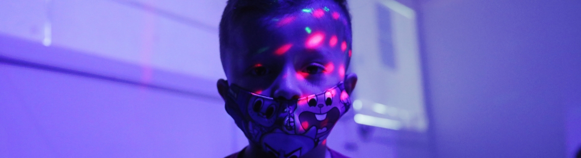 Niño en primera infancia con reflectores de luz en su rostro