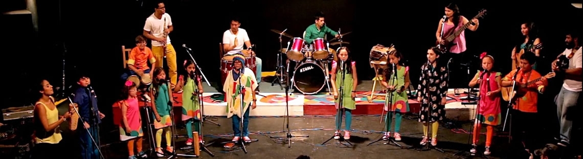 Niños y jovenes en el escenario con instrumentos musicales