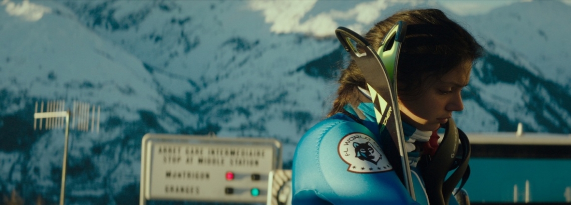 Frame de la película Slalom – Al límite, en el que una mujer vestida de azul mira hacia el suelo