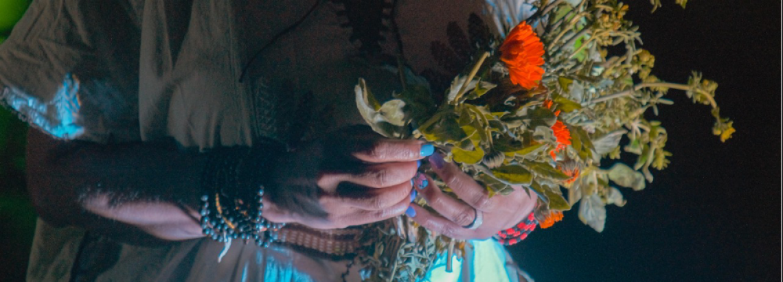 Manos de actriz sosteniendo flores.
