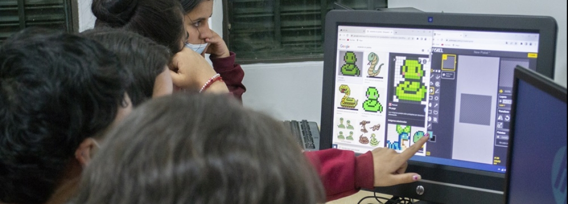 un grupo de jóvenes está frente a un computador 