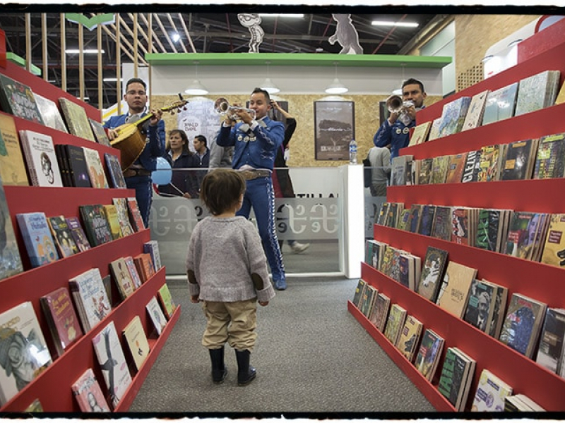 Escena entre libros y mariachis en estand de la Feria del Libro