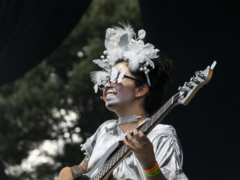Mujer vestida y maquillada de blanco tocando guitarra