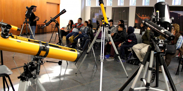 Telescopios y personas asistiendo a un taller