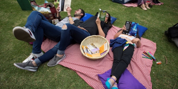 Personas leyendo en parque público