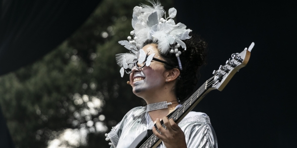Mujer vestida y maquillada de blanco tocando guitarra