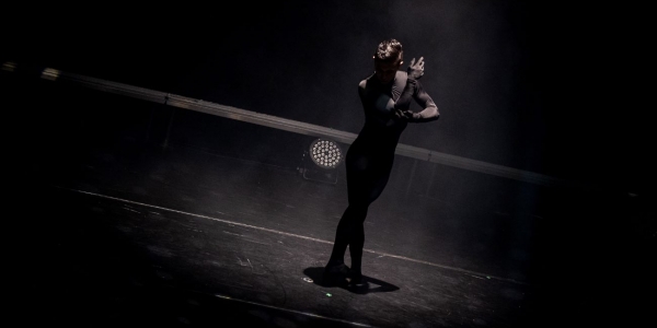 Hombre vestido de negro sobre escenario bailando ballet