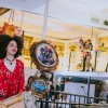 Artista en presentación escenica, joven con cabello afro y vestido rojo.